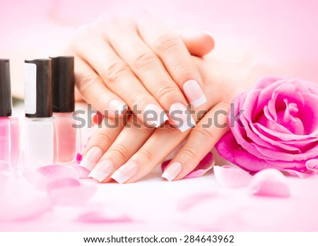 Manicure and Hands Spa. Beautiful Woman hands closeup. Manicured nails and Soft skin. Beauty hands with rose flower petals. Beauty treatment. Beautiful woman's nails with beautiful french manicure