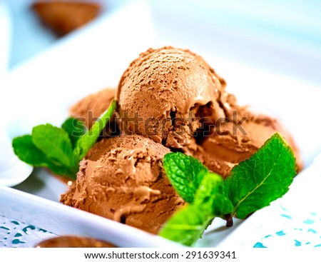 Ice cream scoops with chocolate topping. Brown chocolate icecream served with dark chocolate topping and mint
