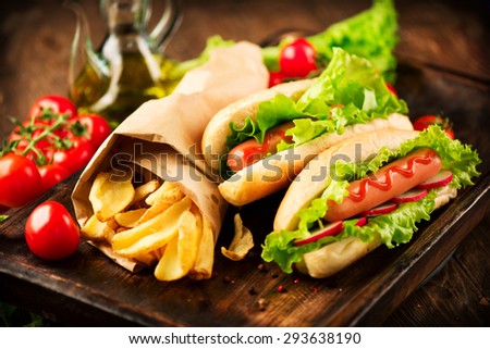 Hot dog. Grilled hot dogs with mustard and ketchup on a picnic wooden table. Sandwich