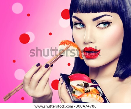 Beauty Fashion model girl eating Nigiri Sushi with chopsticks. Beautiful sexy woman with perfect make up and bob haircut eating healthy japanese food. Diet, dieting concept.