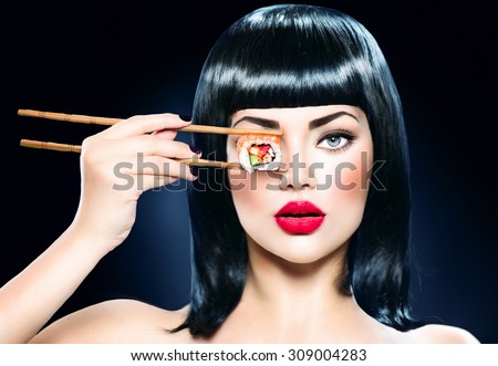 Fashion art portrait of beauty model girl eating Sushi roll, healthy japanese food. Beautiful woman holding chopsticks with sushi. Sexy lady