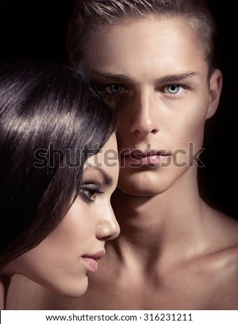 Beauty sexy couple posing isolated on black background. Sexy woman and man together. Portrait. Model blonde boy with his brunette girlfriend posing in studio together. Passion