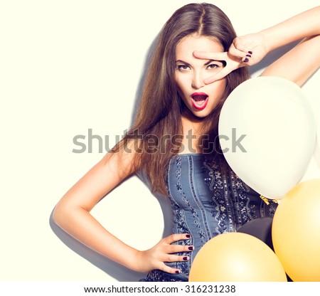 Beauty fashion brunette model girl with colorful balloons posing isolated on white background. Fashion model girl making v-sign or victory gesture. Perfect make up and manicure. Party celebration