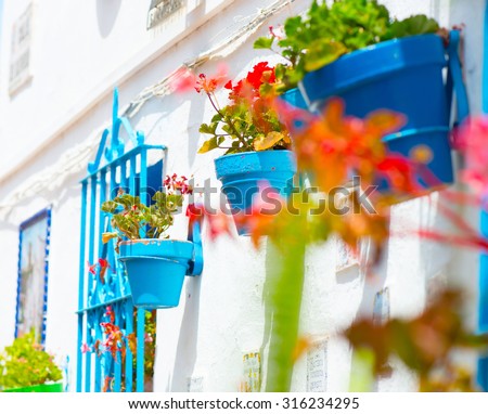 Spain, Torremolinos. Costa del Sol, Andalucia. Typical White Village with flower pots in facades at Spain. Beautiful street decorated with flowers in Spain. Tourism concept