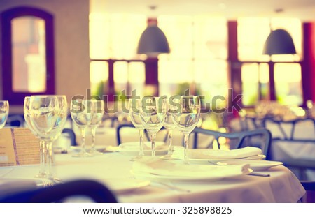 Served dinner table in a restaurant. Restaurant interior. Cozy restaurant table setting. Defocused background