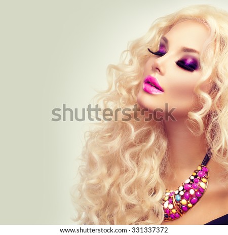 Beauty Girl With Healthy Long Curly Hair. Blonde Woman Portrait. Blond Wavy Hair and bright makeup, vivid make-up, purple lips, smoky eyes and false eyelashes. Holiday make up. Perfect skin