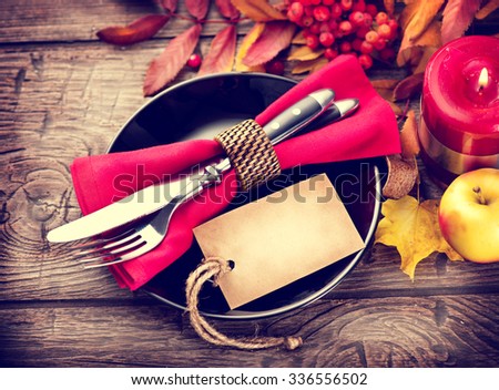 Thanksgiving Dinner. Thanksgiving wooden table served, decorated with bright autumn leaves. Holiday Table setting with invitation blank card