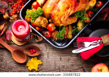 Thanksgiving Dinner. Thanksgiving table served with turkey, decorated with bright autumn leaves. Roasted turkey, table setting