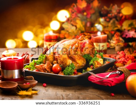 Roasted Turkey. Thanksgiving table served with turkey, decorated with bright autumn leaves and candles. Roasted chicken, table setting. Christmas dinner