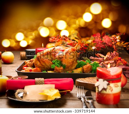 Christmas Dinner. Roasted Turkey on holiday served table. Thanksgiving table served with turkey, decorated with bright autumn leaves and candles. Roasted chicken, table setting.