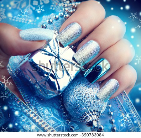 Christmas Nail art manicure. Winter Holiday style bright Manicure Design. Christmas decorations and snowflakes. Nail Polish. Beauty hands. Trendy Stylish Silver and Blue Colorful Nails, Nailpolish