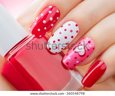 Valentine Nail art manicure. Valentines Day Holiday style bright Manicure with painted hearts and polka dots. Bottle of Nail Polish. Beauty salon. Hand. Trendy Stylish Colorful Nails, Nailpolish