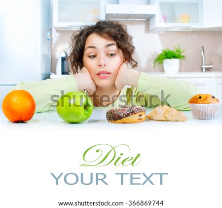 Diet. Dieting concept. Healthy Food. Beautiful Young thinking Woman choosing between Fruits and Sweets. Weight Loss