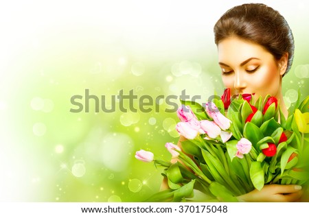 Beautiful girl with a Bouquet of colorful Tulip flowers. Beauty Woman with Spring Flower bunch. Happy surprised model woman smelling flowers. Mother\'s Day gift. Valentine\'s Day. Springtime