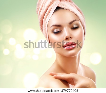 Spa Woman. Beautiful Girl After Bath Touching Her Face. Perfect Skin. Skincare. Young Skin, youth. Beauty female with a towel on her head pampering skin