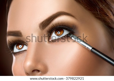 Makeup. Woman Make-up Applying closeup. Eyeliner. Cosmetic Eyeshadows. Eyeline brush for Make up. Beauty Girl with Perfect Skin. Eyelashes. Brown eyes. Makeover