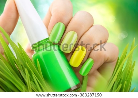 Spring manicure. Fresh Nature trendy green nails. Beautiful nail polish with grass. Green and yellow colors Eco Nail art manicure. Bottle of Nail Polish. Fashion Beauty hands. Stylish Nailpolish