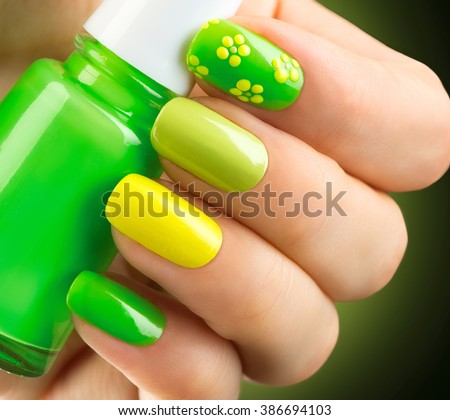 Spring green manicure. Fresh Nature trendy green nails. Beautiful nail polish with grass. Green and yellow colors Eco Nail art manicure. Bottle of Nail Polish. Fashion Beauty hands. Stylish Nailpolish