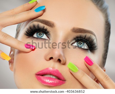 Beauty Girl Portrait with Vivid Makeup and colorful Nail polish. Colourful nails. Fashion Woman portrait close up. Bright Colors. Manicure Make up. Smoky eyes, long eyelashes. Rainbow Colors