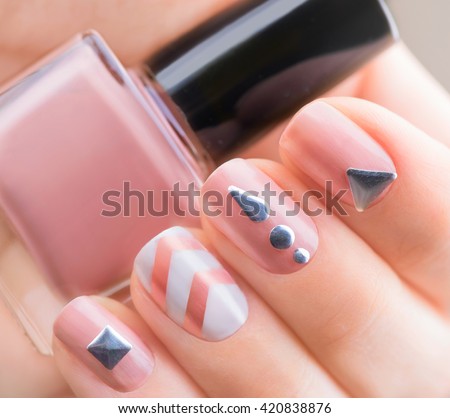 Nail art manicure. Fashion modern design Beige color Manicure with metal accessories. Bottle of Nail Polish. Beauty salon. Hand. Trendy Stylish Colorful Nails, Nailpolish