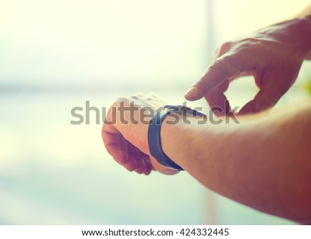 Person using smart watch. Young man making gestures on a wearable smart watch computer device, smartwatch close up (unrecognizable)