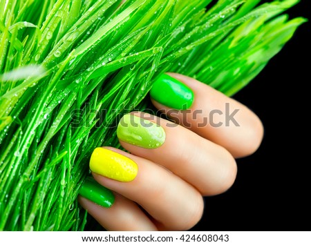Spring manicure. Fresh Nature trendy green nails. Beautiful nail polish with grass. Green and yellow colors Eco Nail art manicure. Bottle of Nail Polish. Fashion Beauty hands. Stylish Nailpolish