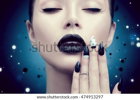 High Fashion Model Girl Portrait with Trendy gothic Black Make up, dark Manicure and accessories. Halloween Vampire Woman portrait with black matte lips and nails over deep blue background
