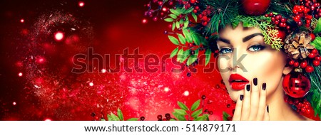Christmas fashion model woman. Xmas New Year hairstyle and make up. Beauty Girl portrait. Gorgeous Vogue style Lady with Christmas decorations on her head, baubles, professional makeup, red lipstick