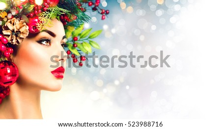 Christmas fashion model woman. Xmas New Year hairstyle and make up. Beauty Girl portrait. Gorgeous Vogue style Lady with Christmas decorations on her head, baubles, professional makeup, red lipstick