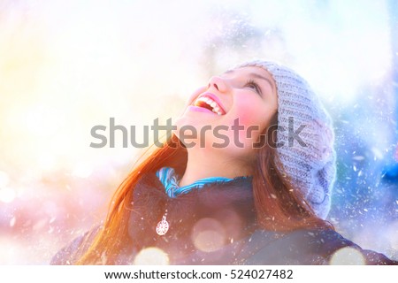 Winter young woman portrait. Beauty Joyful Model Girl raising hands, spinning and laughing, having fun in winter park. Beautiful young woman laughing outdoors. Enjoying nature, wintertime