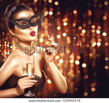 Beauty Glamour Woman celebrating with champagne, wearing carnival mask. party, drinking champagne over holiday glowing background. Christmas and New Year celebration