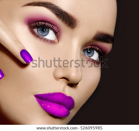 Beauty Brunette Woman with Perfect Makeup. Beautiful Professional Make-up. Red Lips and Nails, perfect eyebrows. Skin care, foundation, contouring. Beauty Girl\'s Face isolated on black background