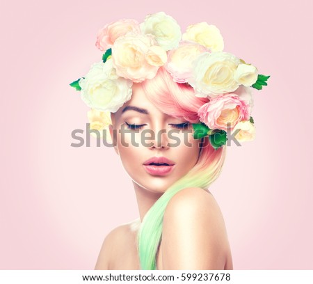 Spring Woman. Beauty Summer model girl with colorful flowers wreath and colorful hair. Flowers Hair Style. Beautiful Lady with Blooming flowers on her head. Nature Hairstyle. Holiday Fashion Makeup.