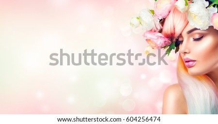 Spring Woman. Beauty Summer model girl with colorful flowers wreath and colorful hair. Flowers Hair Style. Beautiful Lady with Blooming flowers on her head. Nature Hairstyle. Holiday Fashion Makeup.