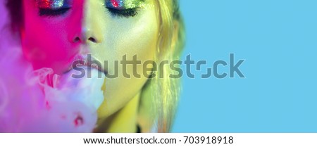 Fashion art portrait of beauty model woman in bright lights with colorful smoke. Smoking girl, Close up of a female inhaling from an electronic cigarette. Night life concept
