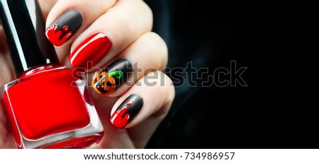 Halloween manicure design ideas. Halloween Nail art design. Nail Polish. Beauty hands. Trendy Stylish Colorful Nails and Nailpolish bottle. Black polish with blood dops and pumpkin. Isolated on black.