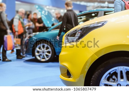 Parked Colorful Brand New Cars. Car Dealership For Sale in Fair Event. Gathering of People for Autos Entertainment or Commercial Activities. Transportation Industry Concept with Person in Photo.