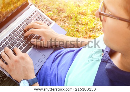 Man work on computer at the park in a sunny day
