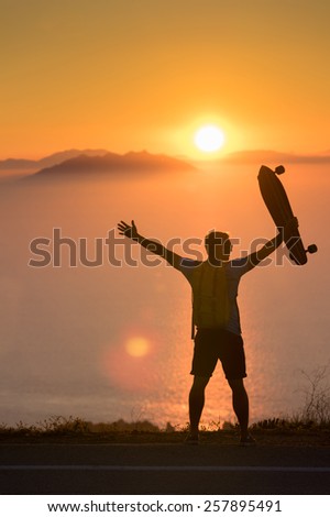 Young traveler hipster watching to the sunset through islands with his luggage and longboard - Inspiration for freedom, nature lover and wild adventure