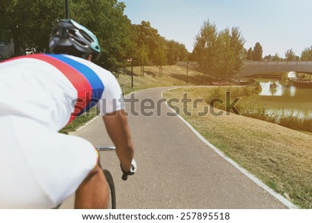 Sportsman riding a bike into the park with lake - Outdoor activity with bicycle and green nature