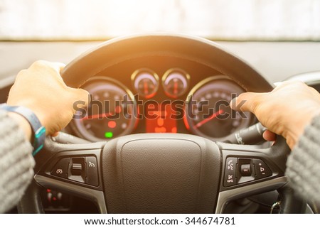 Man ready for driving the car on the freeway. Close up of hands of driver on steering wheel of car. Personal point of view of machine\'s front glass. Main focus on the lather.