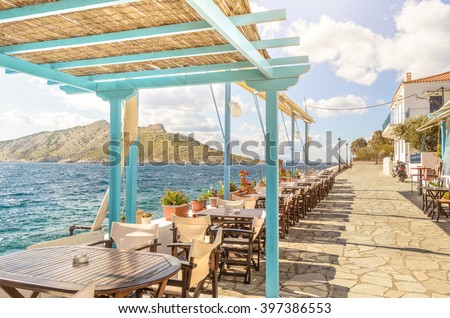 Summer photo with panoramic view from Aegina island in Greece. Beautiful place for making lunch on seafront with wooden roof of bar and restaurant. Magic moment during sunny day for chilling and relax