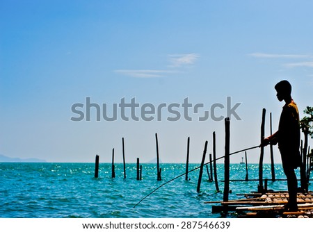 boy stand alone on pontoon and  fishing in the sea