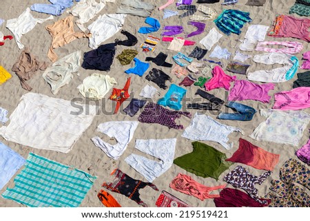 AGRA,INDIA - 25/03/2013 : Laundry service in Yamuna riverside in Agra city ,India.After washing the clothes,linen and all other fabric, laundries spread out on the sand of riverside to dry