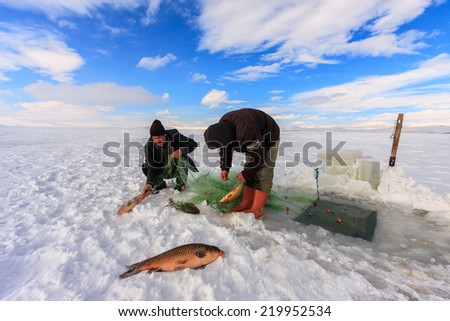 KARS,TURKEY - 30/01/2013 : Fishermen catches fishes on Lake Cildir (Cildir Golu) which is frozen every winter.The Lake is located on Eastern Anatolia,Kars which is one of the coldest city in Turkey.