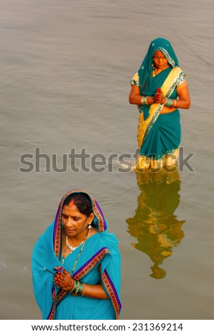 VARANASI,INDIA - October 29,2014 : Unidentified Indian women pray and devote for Chhath Puja festival on Ganges river side in Varanasi,India