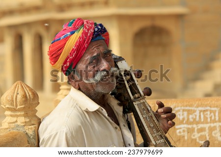 JAISALMER,INDIA - November 8,2014 : Unidentified indian man plays an indian musical instrument similar to Sarangi in Jaisalmer.