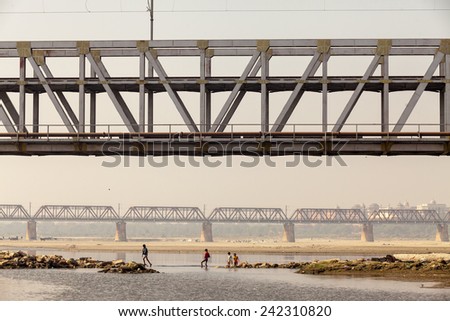 AGRA,INDIA - March 26,2013 : Unidentified children plays and walks under the railway bridge on yamuna river in Agra,India.