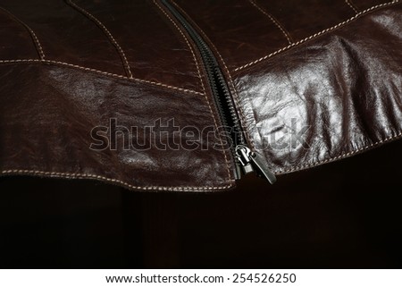 Detail of leather coat with scarf and the zipper