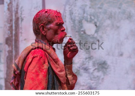 MATHURA,INDIA - March 28,2013 :Unidentified man painted  with  powder paints and water thrown by the others during the Holi celebration in Mathura.Holi festival  is one of the most colorful event